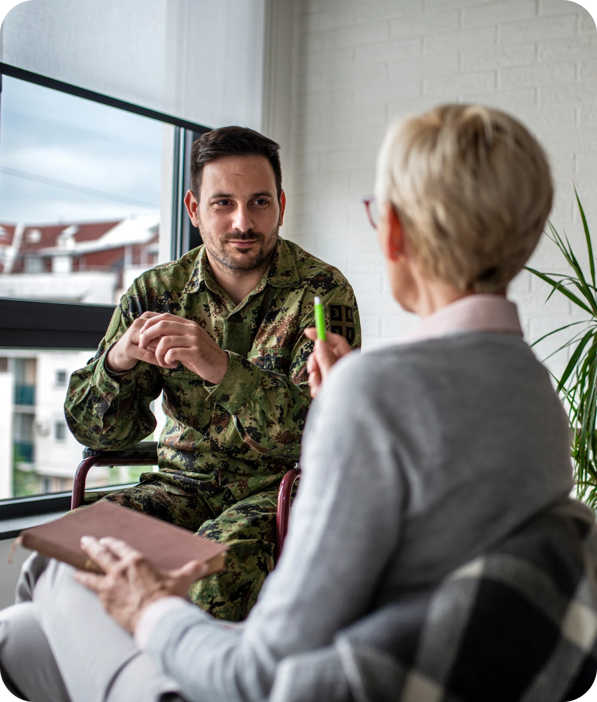Military personnel in discussion with therapist.